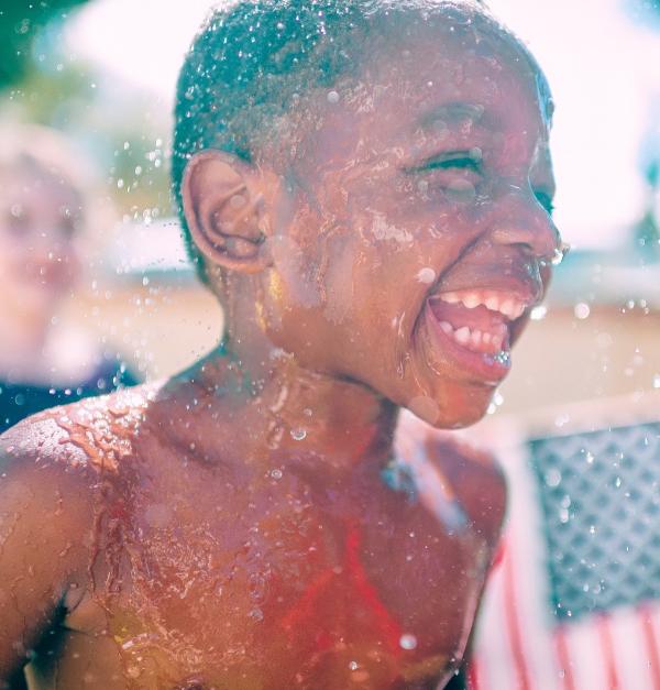 Jongen lacht en speelt in het water