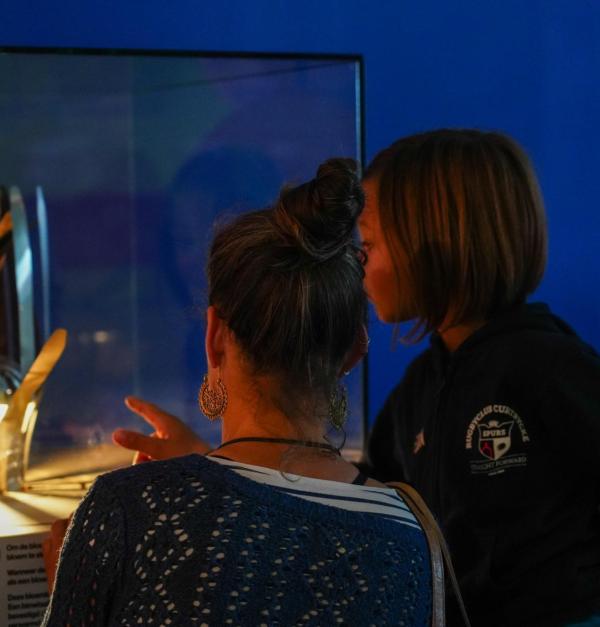 Vrouw en kind kijken naar een experiment in Technopolis