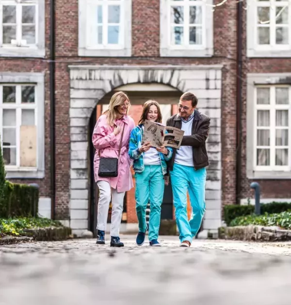 Drie mensen kijken op een kaart in het Begijnhof van Hasselt