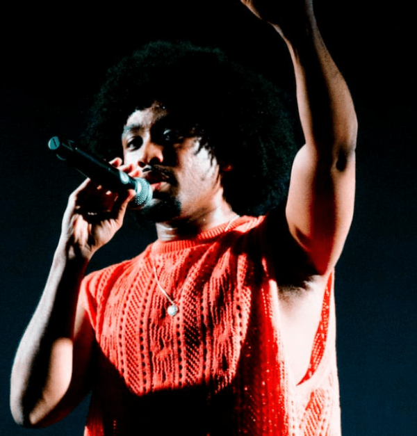 Man met afro die optreedt en zijn arm opsteekt