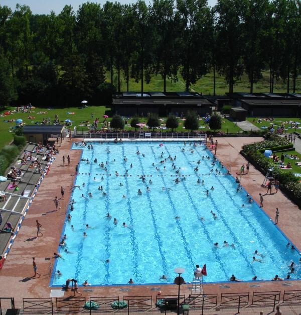 Een groot openluchtzwembad omringd door een ligweide.
