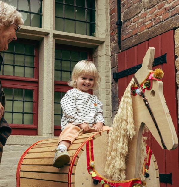 Meisje op een houten paard in het Huis van Alijn